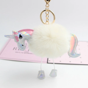 Detailed view of unicorn plush pom pom keychain with iridescent leather and gold clasp