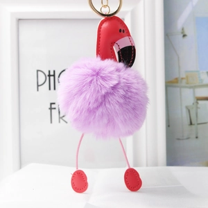 Détail d'un porte-clés flamant rose en peluche violette avec pattes en cuir et clip doré