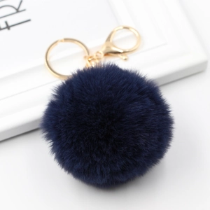 Detail of soft navy blue faux fur pompom keychain with golden lobster clasp and ring
