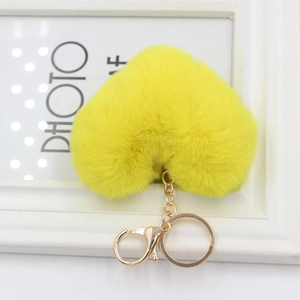 Detail of soft yellow heart-shaped plush keychain with a gold metal lobster clasp