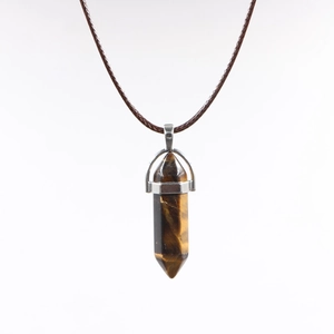 Macro detail of hexagonal tiger eye stone pendant with brown braided wax cord necklace