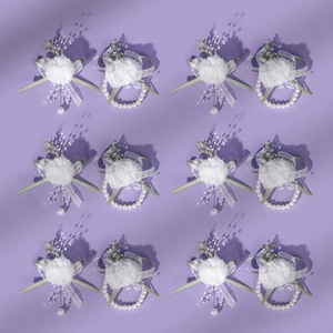 Macro detail of white tulle wedding corsages with pearls and green ribbons on purple back