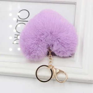 Close-up of fluffy purple heart-shaped plush keychain with golden lobster clasp and ring