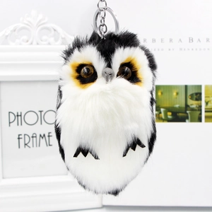 Détail du porte-clés hibou en fausse fourrure avec clip en métal argenté sur fond blanc