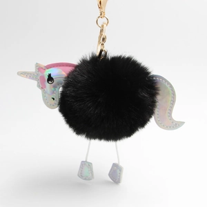 Close-up of black plush unicorn keychain with holographic silver details and gold metal clasp