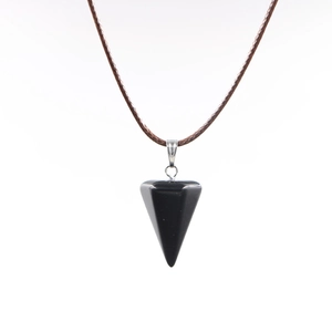 Detailansicht eines polierten schwarzen sechseckigen Steinanhängers mit braunem Kordelhalsband
