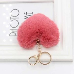 Close-up of a pink heart-shaped plush keychain with a gold metal lobster clasp