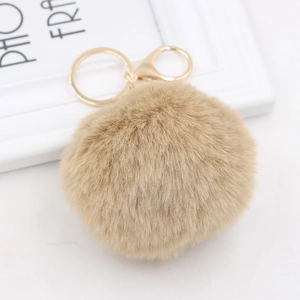 Detailed view of fluffy light brown pompom keychain with golden metal clasp and ring