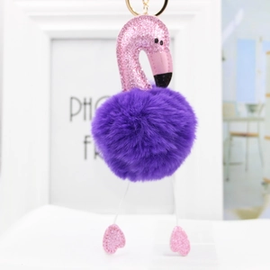 Detail of pink glitter flamingo head and purple faux fur pompom on golden keychain