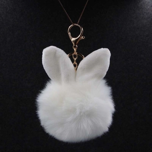 Détail du porte-clés oreilles de lapin en peluche blanche avec pompon et fermoir doré