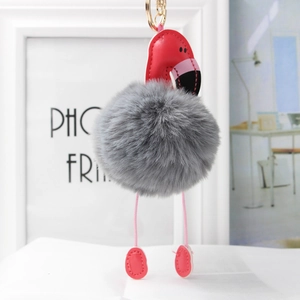 Détail d'un porte-clés flamant rose avec pompon en fourrure grise et boucle dorée