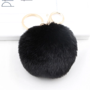 Close-up of fluffy black faux rabbit fur pom pom keychain with gold lobster clasp and ring