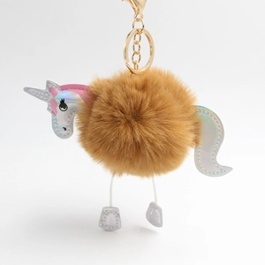 Detail of plush brown unicorn pompom keychain with iridescent silver faux leather accents