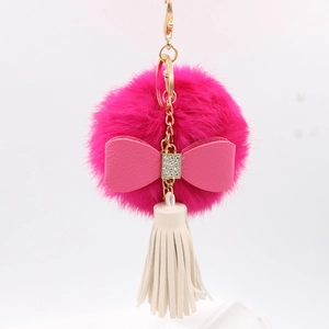 Detail of rose pink faux fur keychain with rhinestone bow and white leather tassel