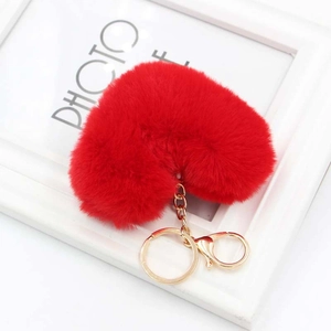Detailed close-up of vibrant red plush heart keychain with gold-tone hardware links