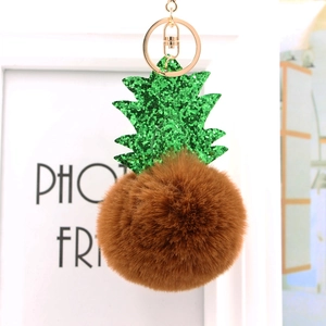 Gros plan d'un porte-clés ananas en fourrure synthétique marron et feuilles pailletées