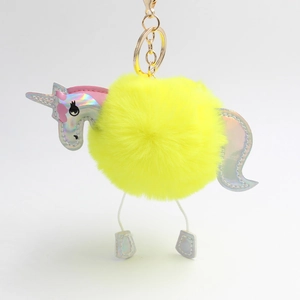 Detail of neon yellow plush unicorn keychain with iridescent silver leather accents