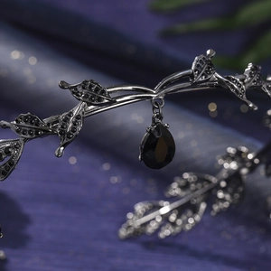 Detail view of gothic black leaf crown with shimmering rhinestones and a pear-cut gem drop