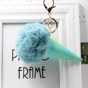 Close-up of fluffy blue faux fur ice cream pom-pom and teal leather cone keychain