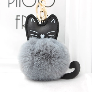 Detail of cute cat pompom keychain with soft grey faux fur and black leather cat head charm