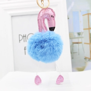 Close-up of pink sequin flamingo pendant with blue faux fur pompom and gold metal keychain