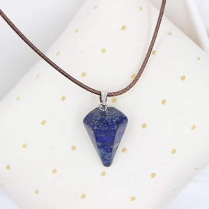 Nahaufnahme eines hexagonalen Lapis Lazuli Anhängers mit Goldflecken an brauner Kordel