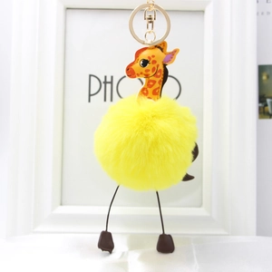 Close-up of yellow faux rabbit fur giraffe keychain with gold metal ring detail