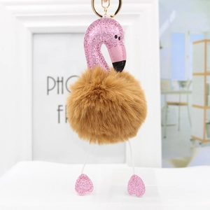 Close-up of flamingo plush keychain with pink glitter leather and golden metal clasp