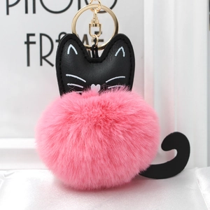 Close-up of fluffy pink pom pom keychain with black cat leather details and gold hardware