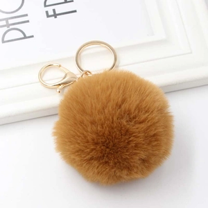 Detail of a fluffy brown faux rabbit fur keychain with a gold lobster clasp and metal ring