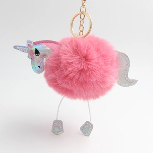 Close-up of pink fluffy unicorn plush keychain with holographic details and gold metal hook