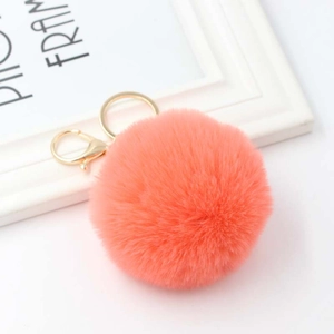 Detail of coral orange plush faux rabbit fur pom pom keychain with gold lobster clasp and ring