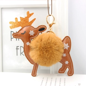 Detail of faux fur pompom deer keychain with snowflake leather and gold glitter antlers