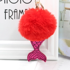 Détail du pompon en fausse fourrure rouge et queue de sirène rose pailletée sur porte-clés