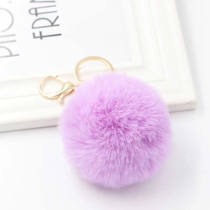 Detail of soft purple faux rabbit fur pom pom keychain with a golden metal lobster clasp