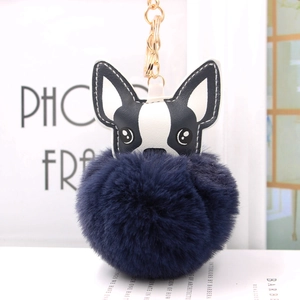 Dettaglio del portachiavi a forma di cucciolo con un grande pompon in pelliccia sintetica blu