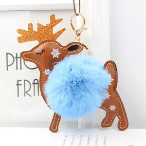 Detail of reindeer charm with blue faux fur pompom, gold antlers, and metallic clasp