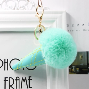 Mint green plush faux fur ice cream keychain with gold hardware on white frame background