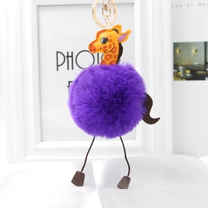Detail of a purple faux fur giraffe plush keychain with a gold metal ring and cute animal charm