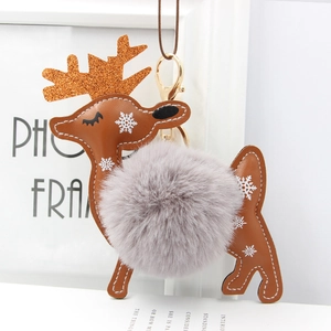 Detail of reindeer keychain with grey faux fur pom pom and festive snowflake patterns