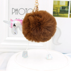 Detail of unicorn pompom keychain with holographic wings and gold metal clasp
