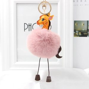 Close-up of pink fluffy giraffe plush keychain with golden metal ring and soft texture