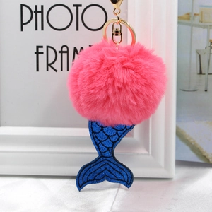 Détail d'un porte-clés à pompon rose avec pendentif en queue de sirène à paillettes bleues