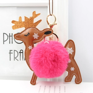 Detail of Christmas reindeer keychain featuring brown leather and soft pink faux fur pompom