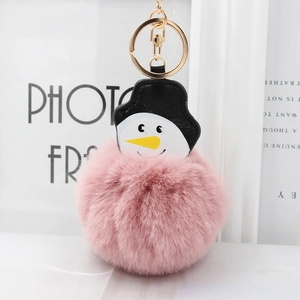 Détail du porte-clés pompon rose avec figurine de bonhomme de neige et anneau doré