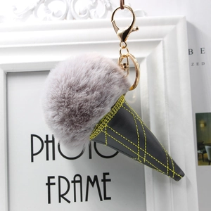 Detail of grey fur ball ice cream keychain with black leather cone and gold metal clasp