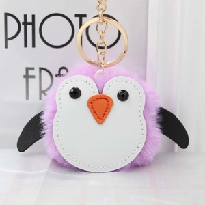 Close-up of a purple penguin faux fur keychain with a golden metal ring and heart-shaped beak