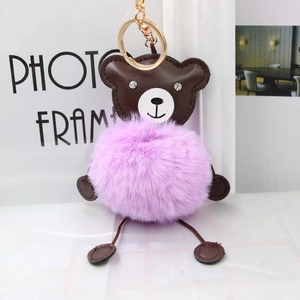 Detail of cute purple plush bear keychain with soft faux fur and gold metal clasp