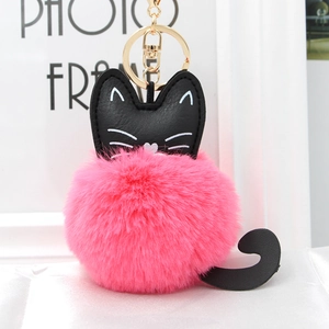 Close-up of pink fluffy plush cat keychain with black leather ears and gold lobster clasp