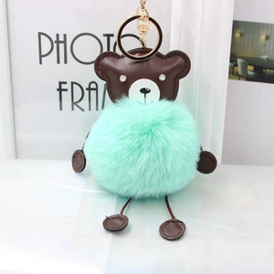 Light green faux fur bear pompom keychain with brown leather accents and gold hardware